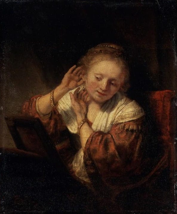 Young woman trying on earrings - Rembrandt van Rijn